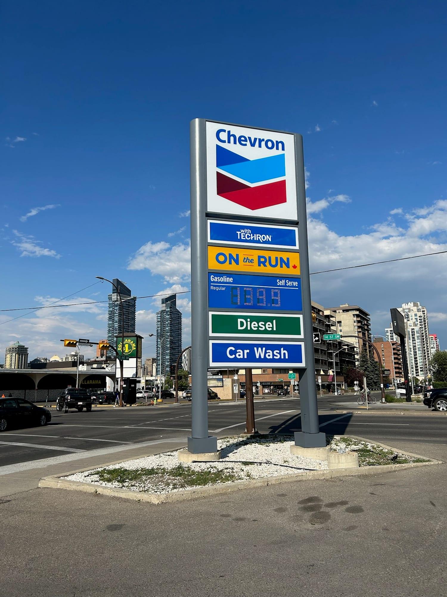 Repainted service station price sign against a clear sky