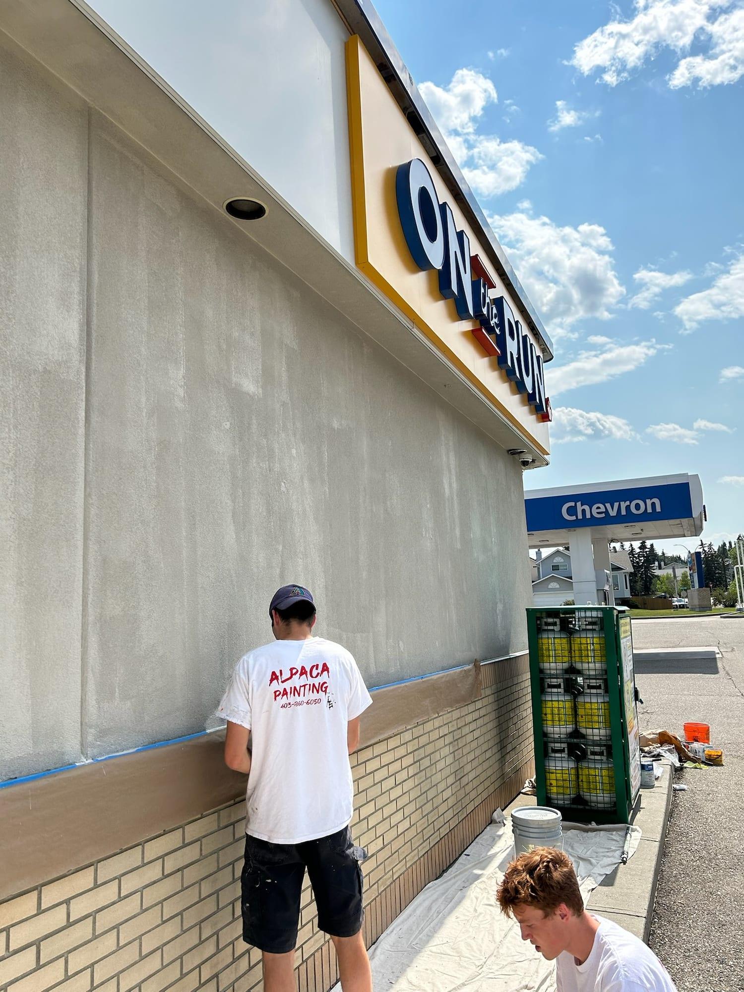 Painter cutting in along the base of a freshly painted commercial wall