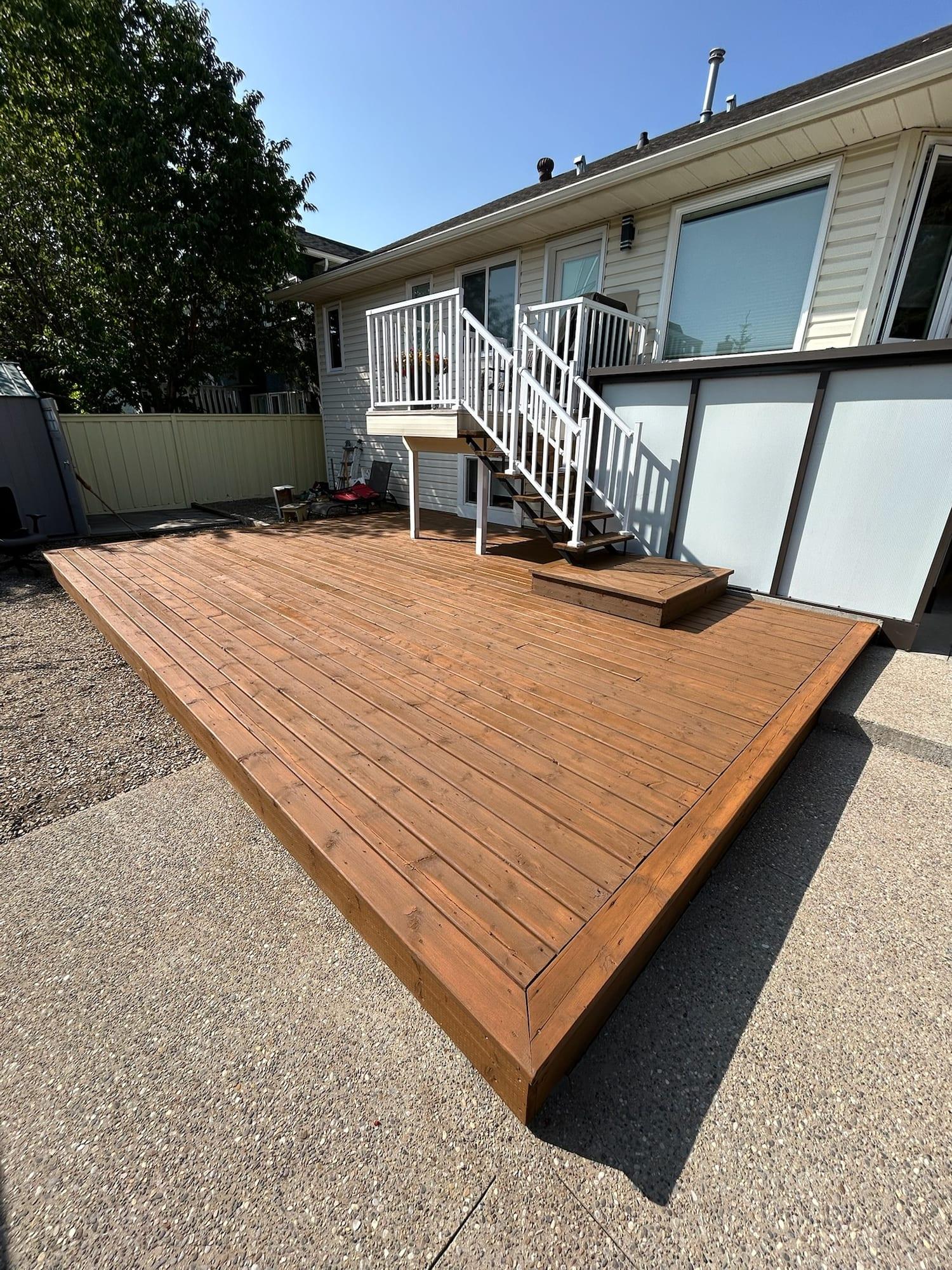 Freshly stained backyard deck with white painted railings